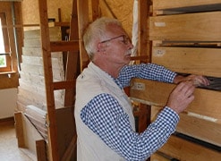 Siegfried Merten greift in Holzschublade in Werkstatt